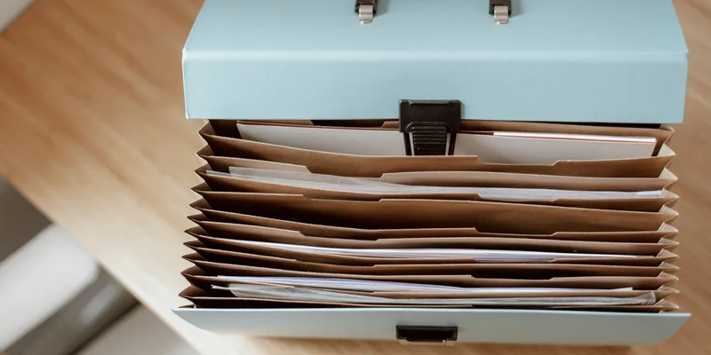 An open document wallet of paperwork on a wooden table