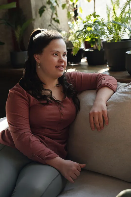 A woman resting on a sofa at home in warm afternoon light