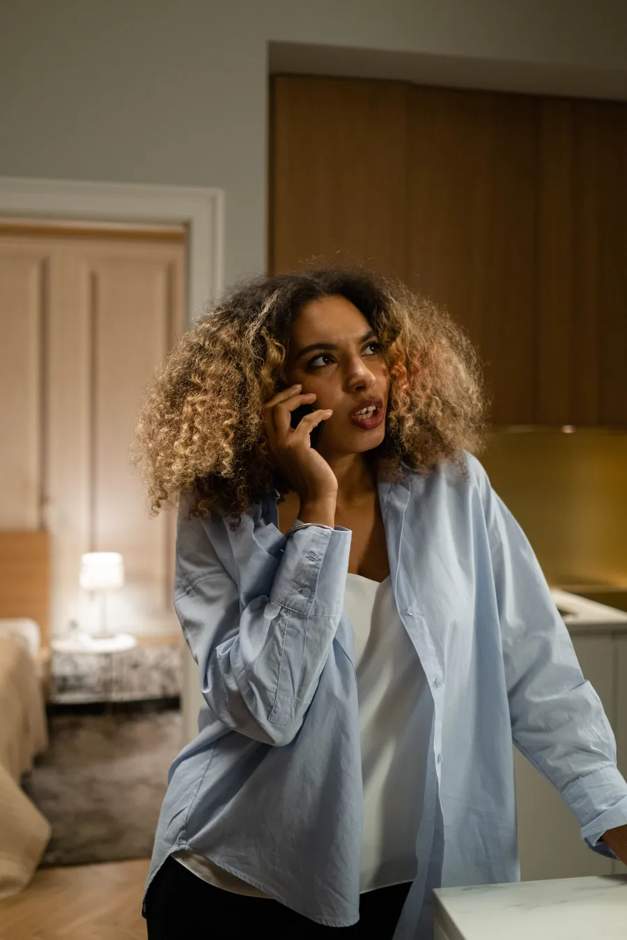 A woman taking a phone call at home in the evening