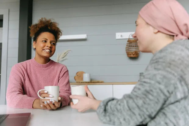 Two people sitting together over coffee at home, talking through a plan